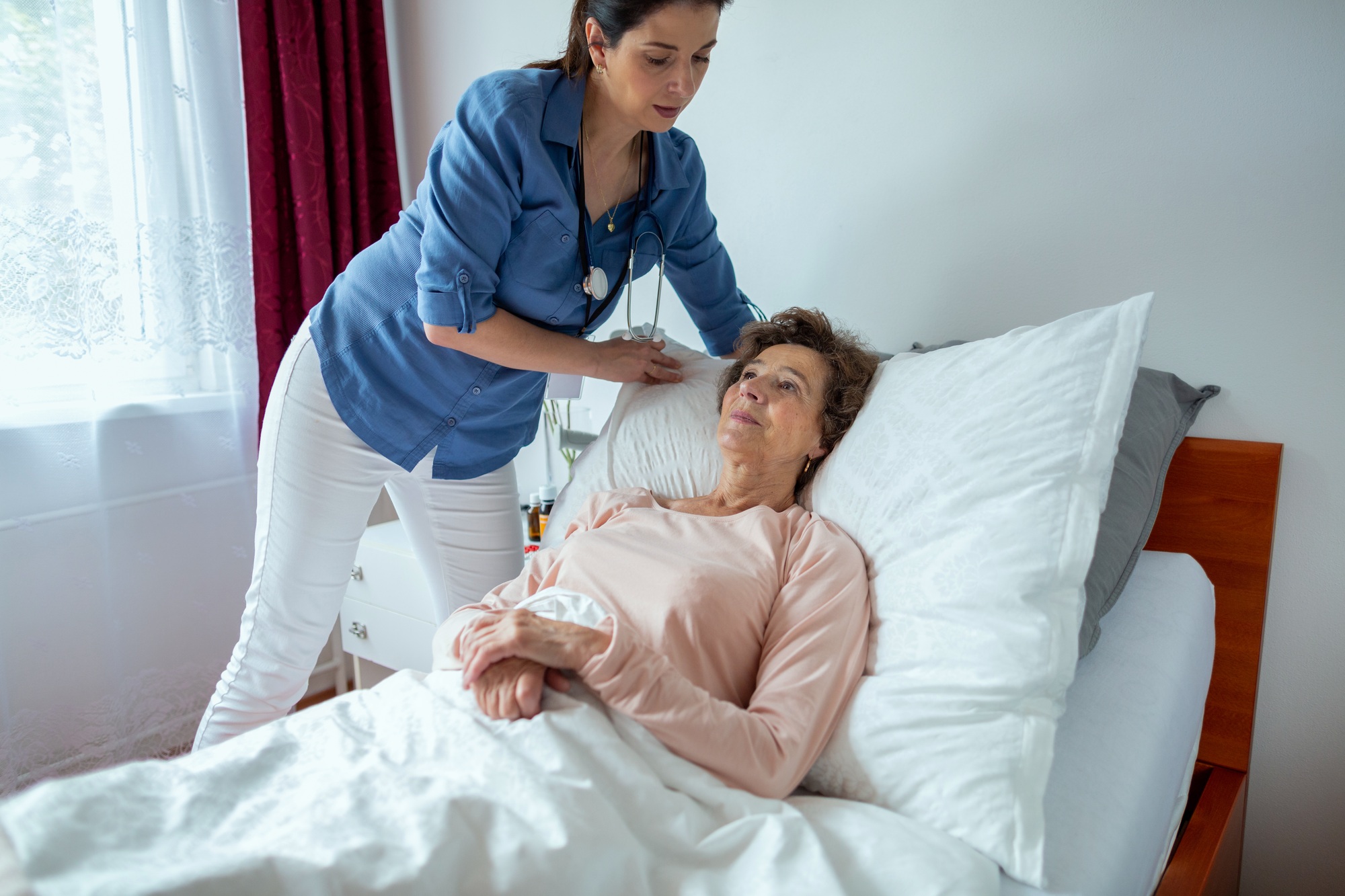 Home Nurse Making Elderly Patient Bed.