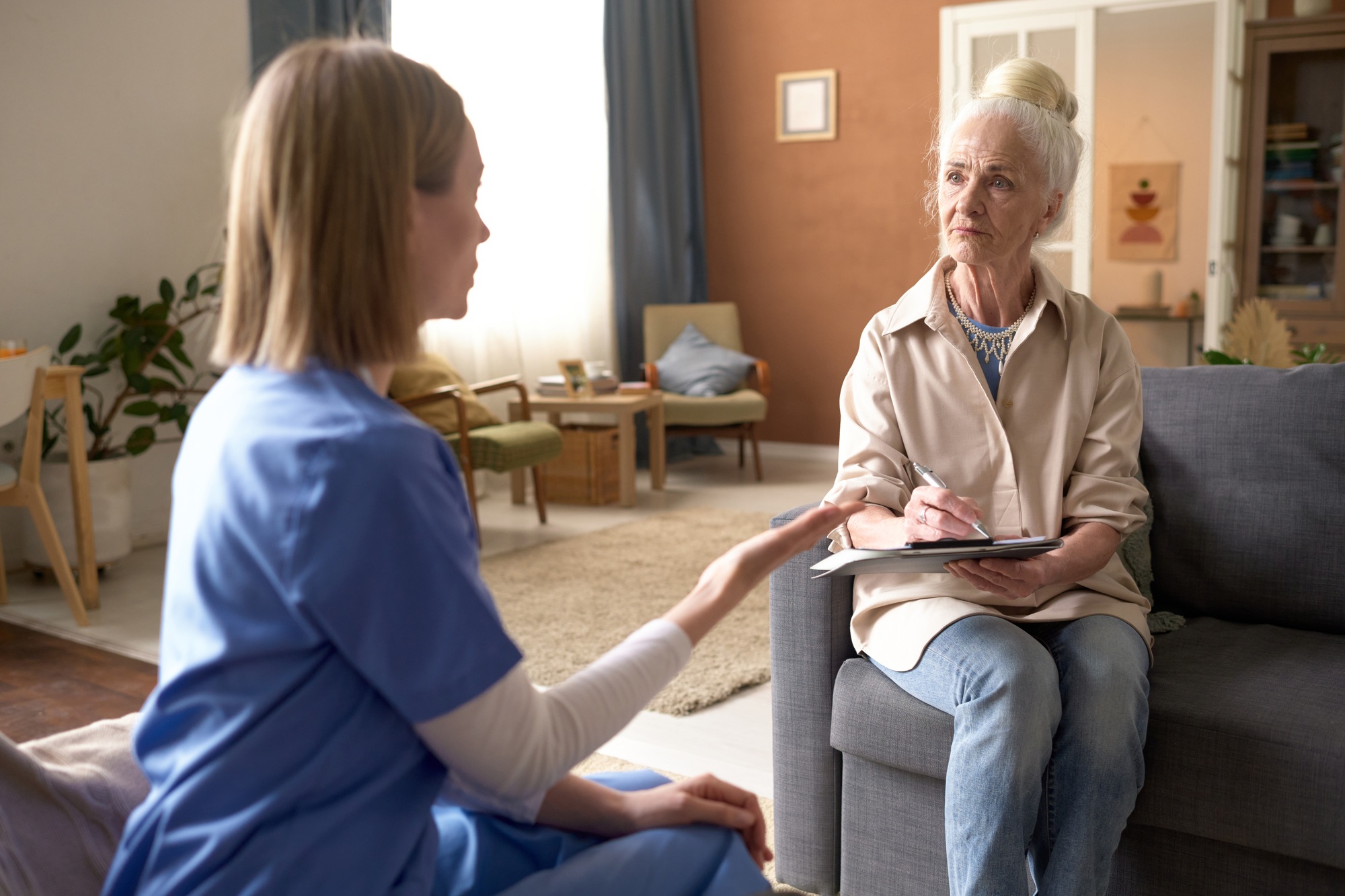 Nurse talking to senior woman at home